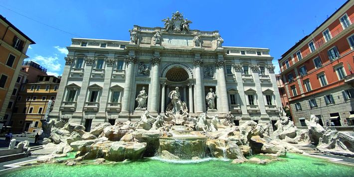 Der Trevibrunnen in Rom mit seinen Wsserspeihern lädt Touristen zum Verweilen ein.