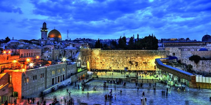 Das Foto zeigt zur baluen Stunde die Klagwemauer in Jerusalem und dahinter den Felsendom auf dem Tempelberg.