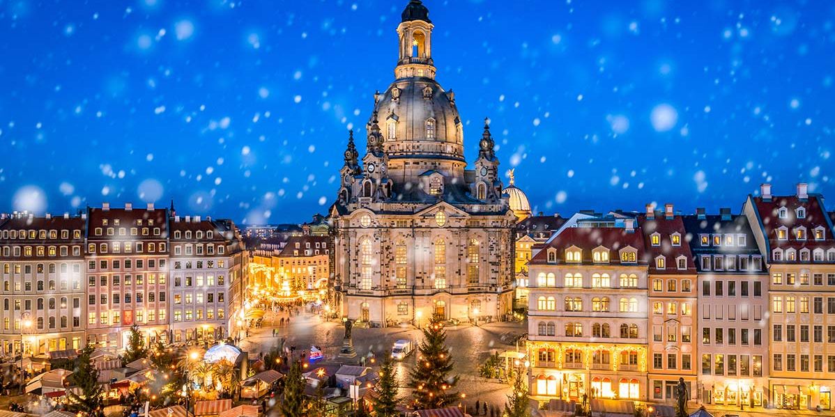 Blick auf die Dresdner Frauenkirche im adventlichen Licht mit dem Weihnachtsmarkt.
