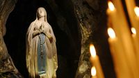 Die Mariengrotte in Lourdes als Andachtsort mit brennenden Kerzen.