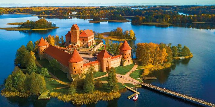 Die spätmittelalterliche Burganlage der Wasserburg Trakai aus dem 14. Jahrhundert liegt malerisch inmitten der umgebenden Seenlandschaft, eingebettet in ein herrliches Naturensemble.